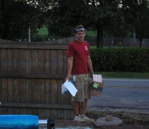 Man standing by a wooden fence