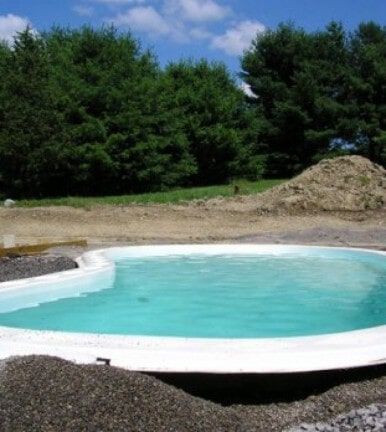 Small above-ground pool with turquoise water in a grassy yard