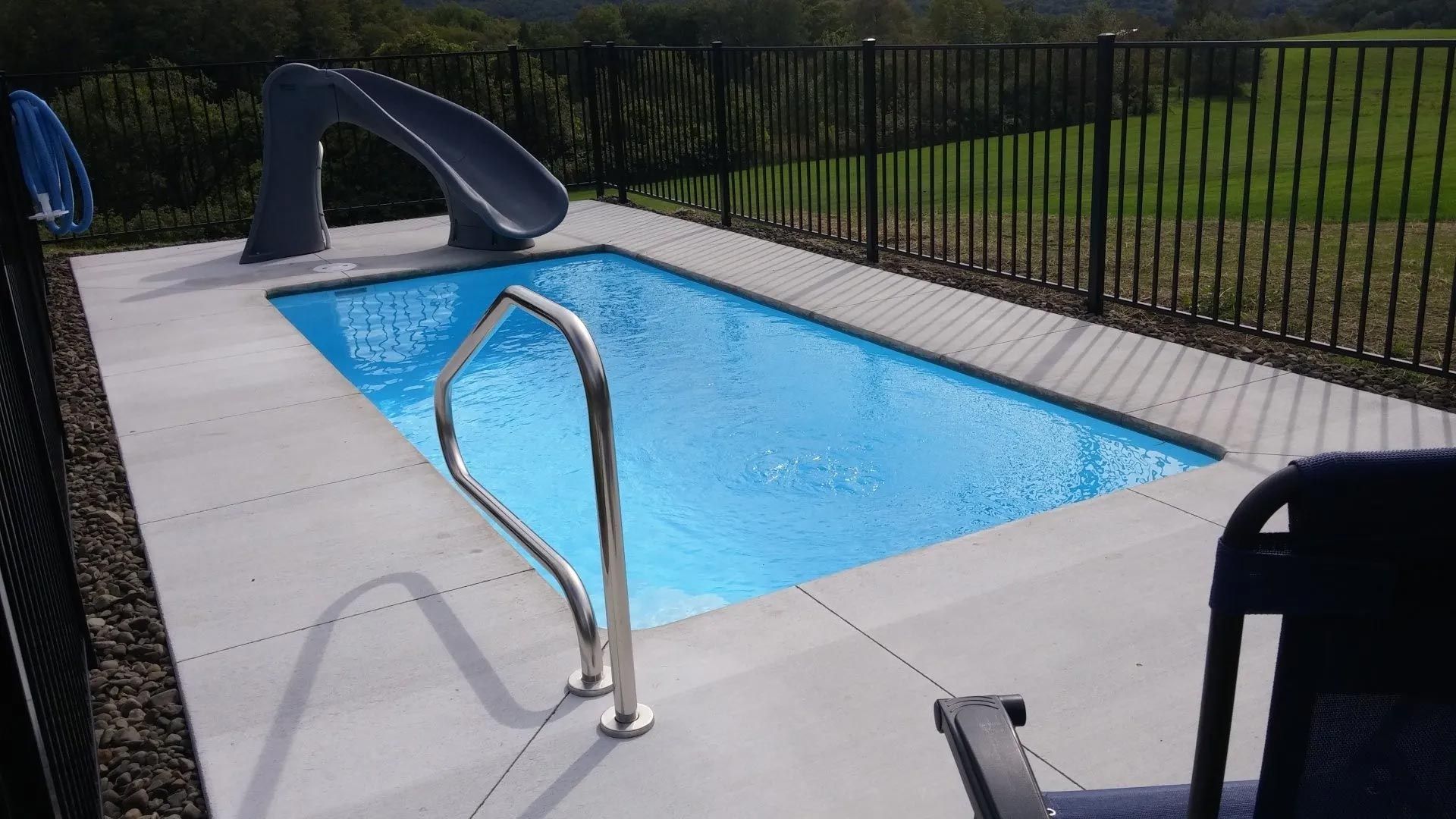 Rectangular backyard pool with metal handrail