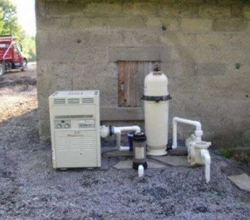 Outdoor water treatment equipment beside a concrete wall