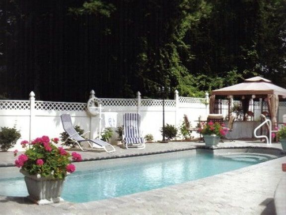 Backyard pool with white fence