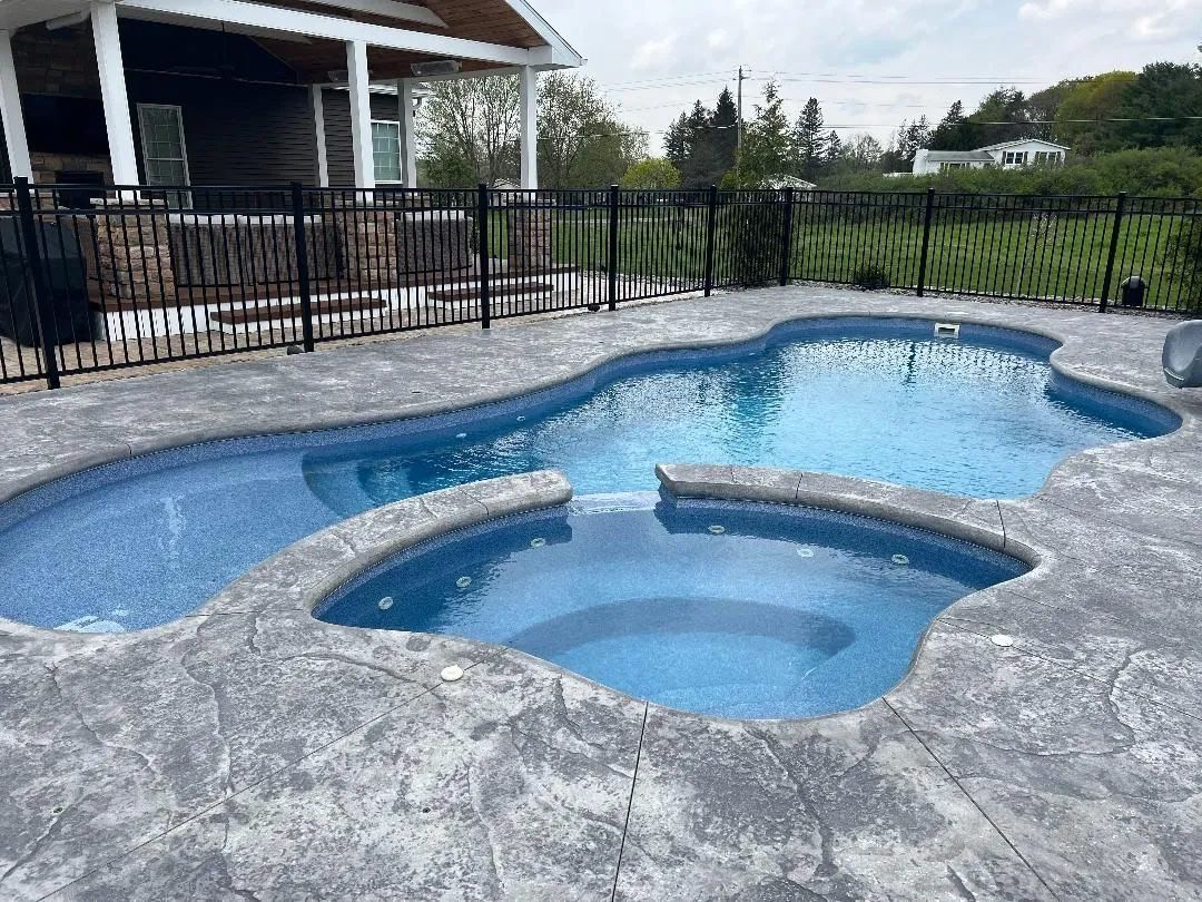 Blue backyard pool with raised spa