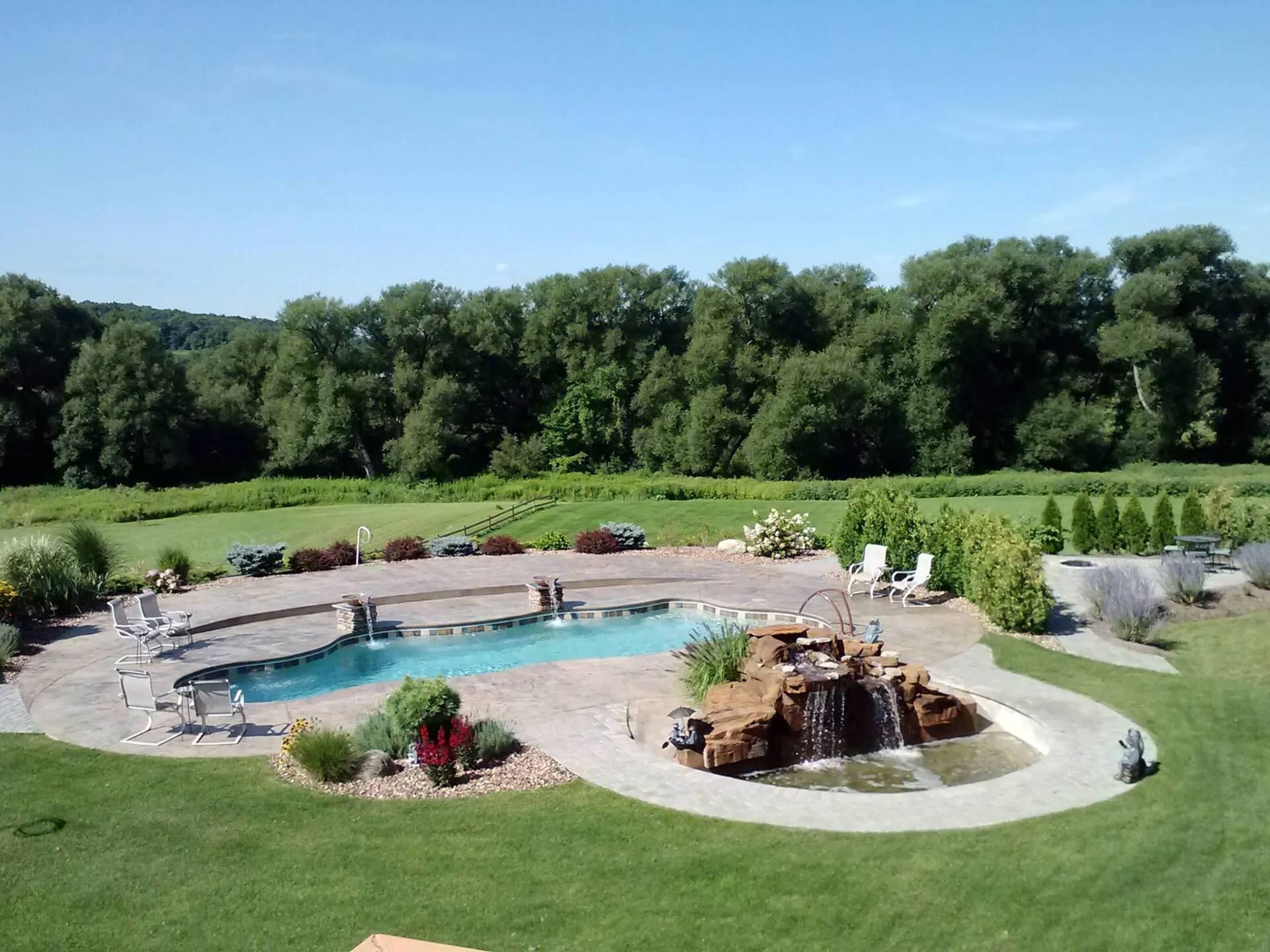 Backyard landscape with a curved swimming pool