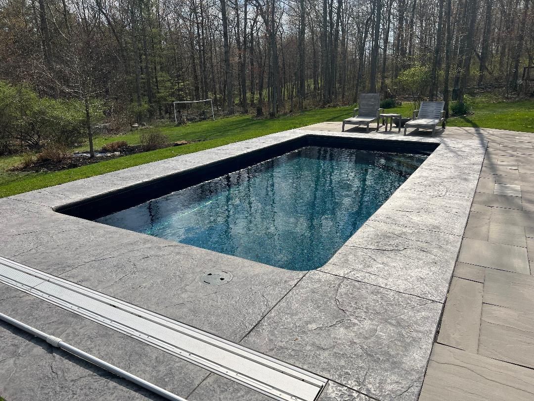 Rectangular outdoor swimming pool with concrete deck