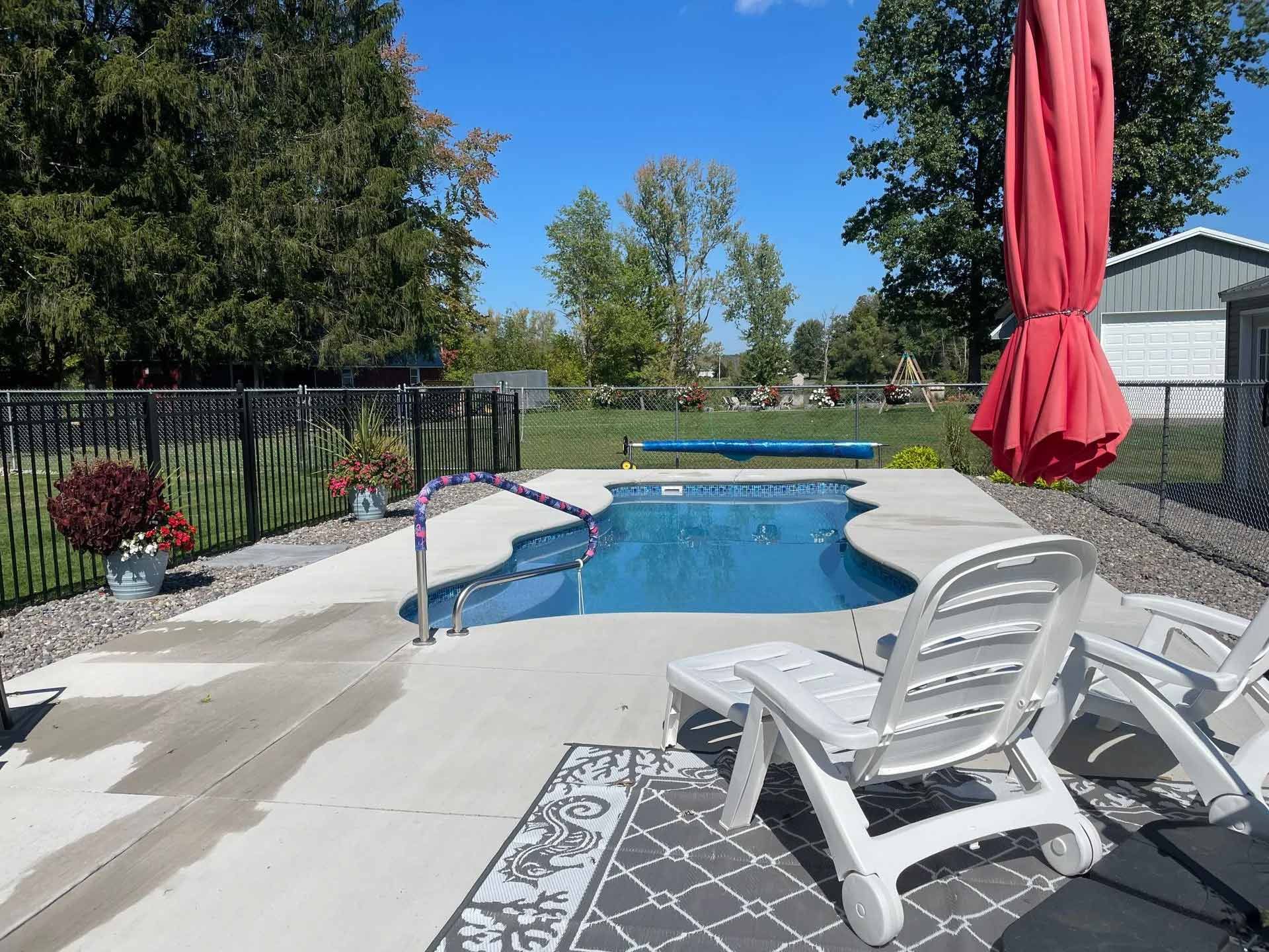 Backyard pool with white lounge chairs