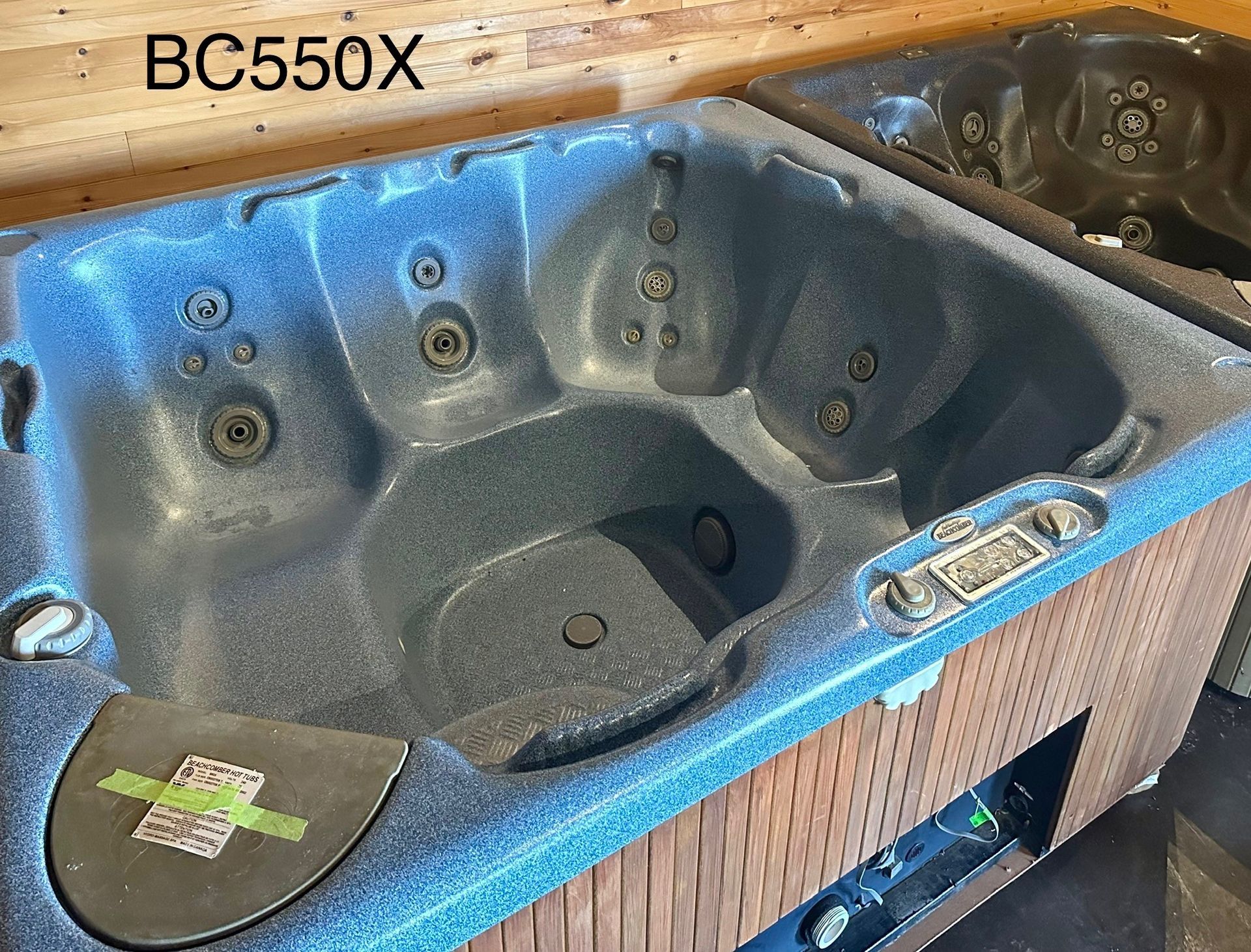 Blue-gray hot tub spa with built-in seats in a showroom or store display