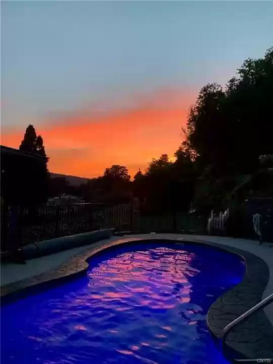 Backyard swimming pool at sunset