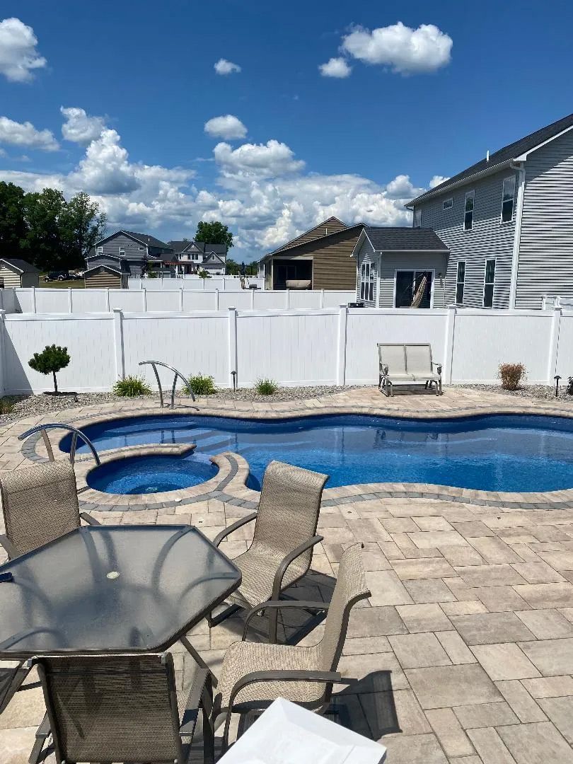 Backyard pool with tables and chairs in patio
