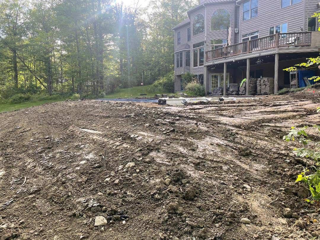 Mud-covered yard beside an elevated house deck
