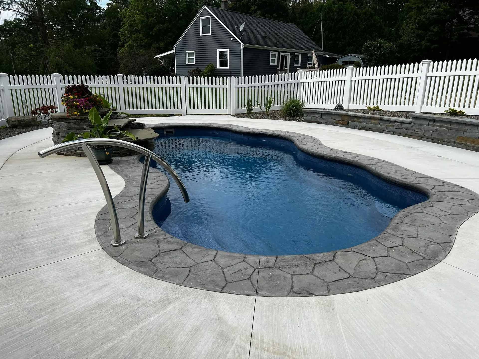 Backyard swimming pool with curved stone deck