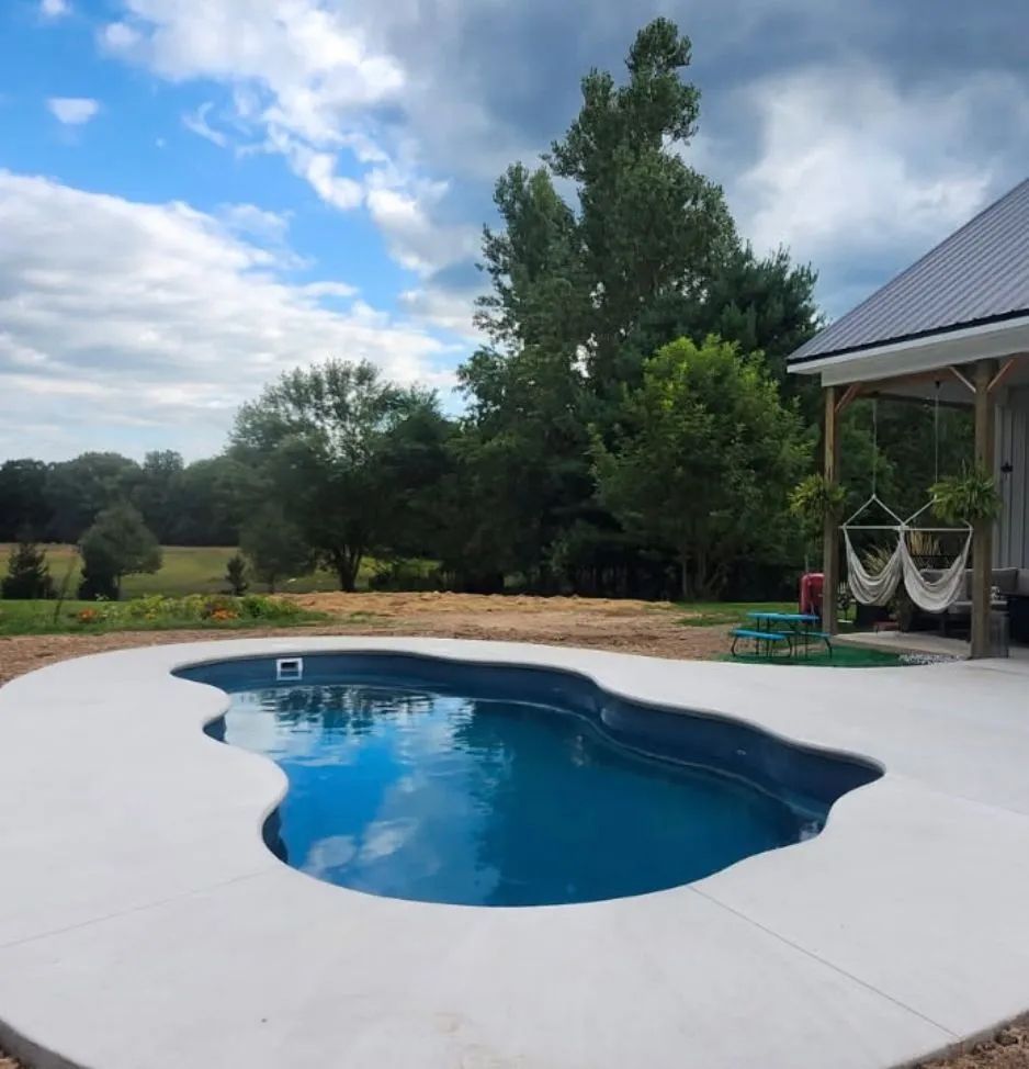 Backyard pool with blue water beside a patio
