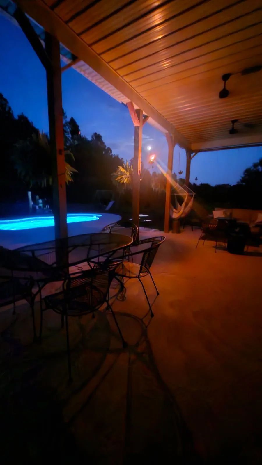 Patio at dusk with a glowing blue pool