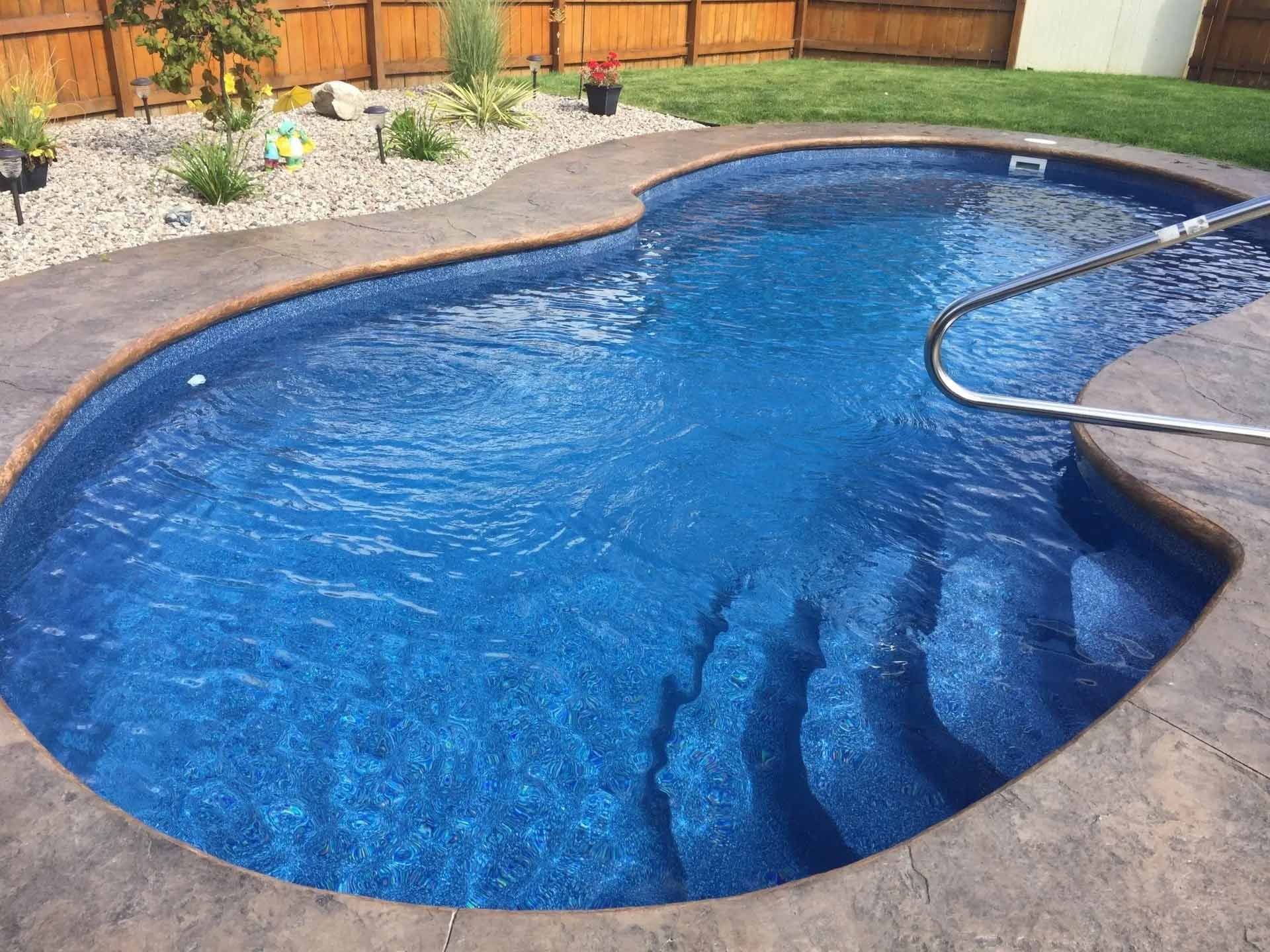 Curved swimming pool with wooden fence