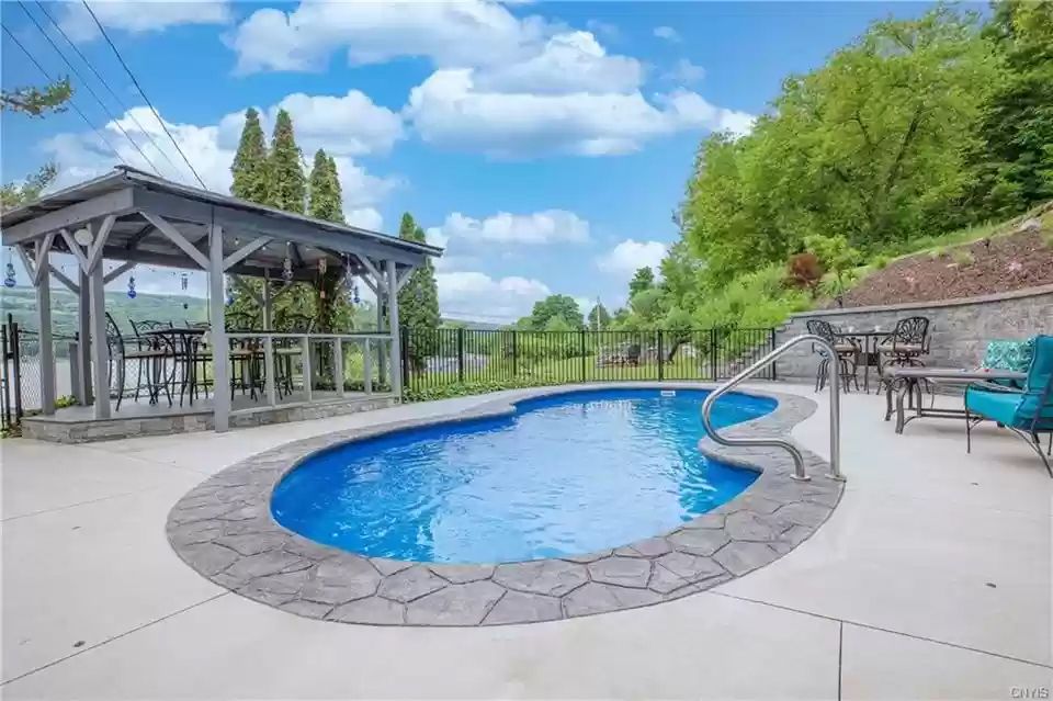 Wide backyard pool and concrete deck