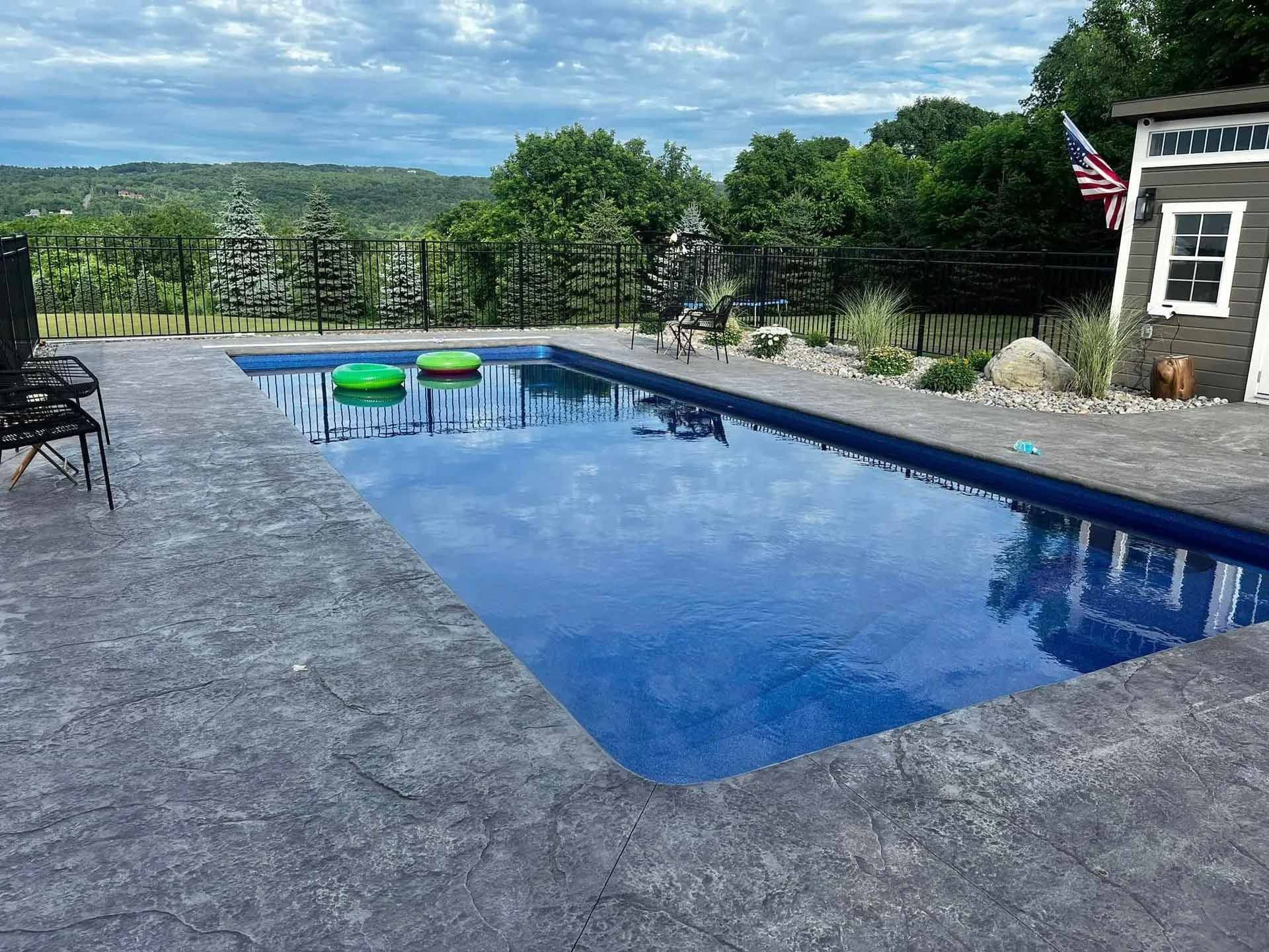 Swimming pool with stone deck in backyard