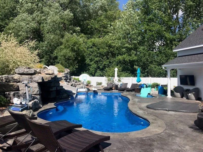 Backyard pool with rock waterfall under a sunny day