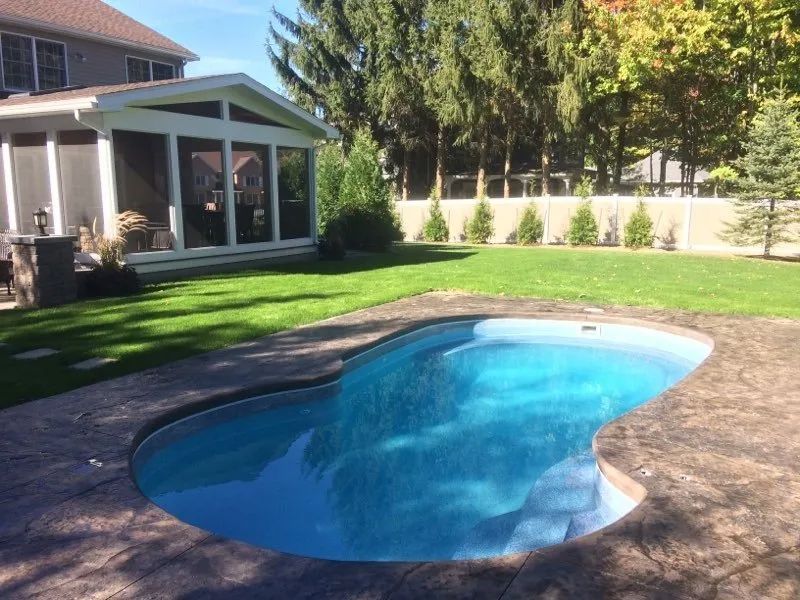 Backyard with pool and green lawn