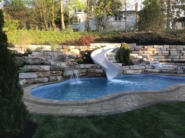 Backyard pool with a white waterslide