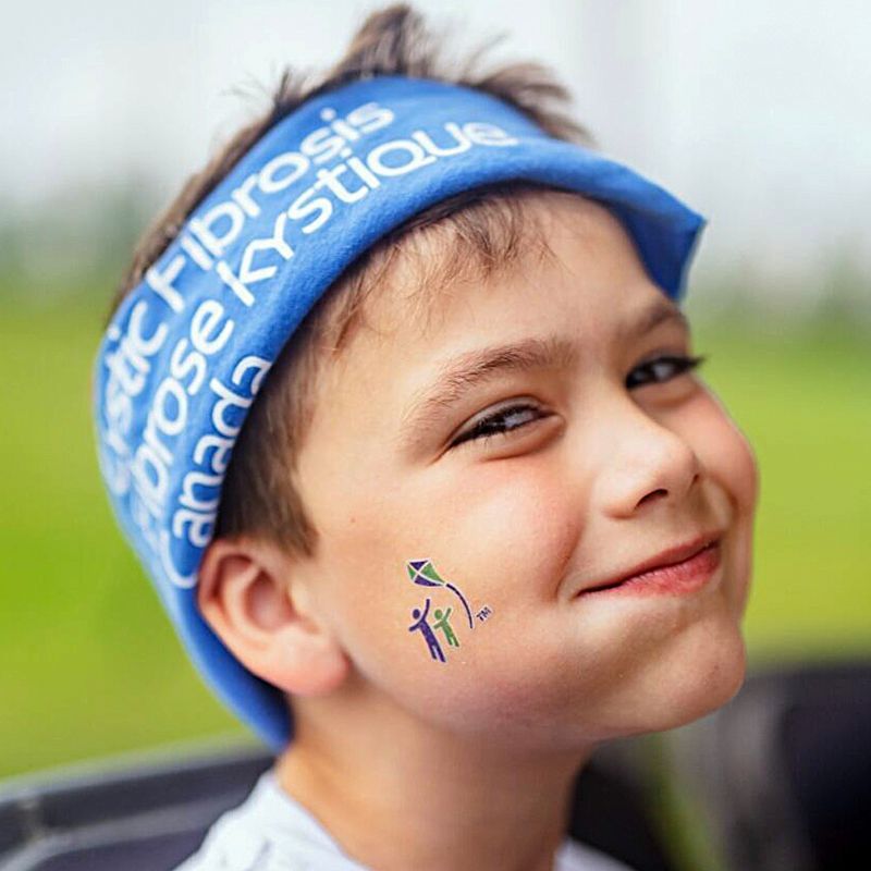 Jeune garçon portant des vêtements d'événement souriant à la caméra.