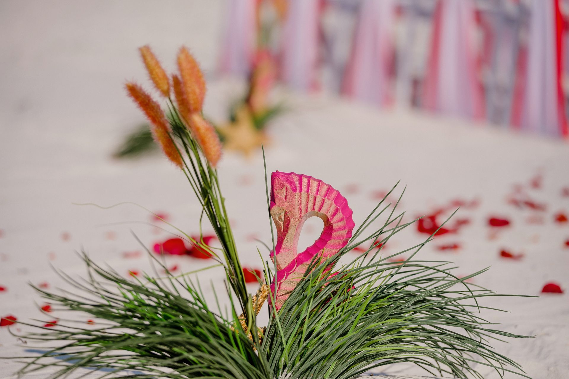 Pink and orange floral arrangement with green grass in a decorative setting