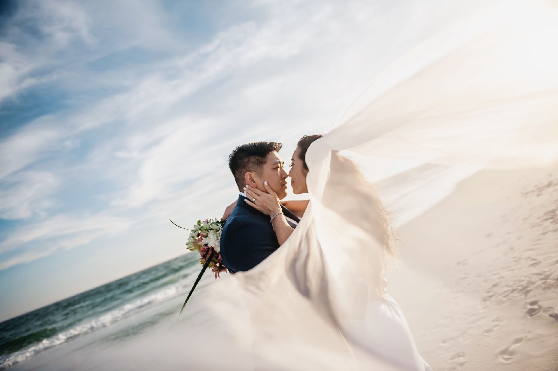 bride and groom kissing on beach