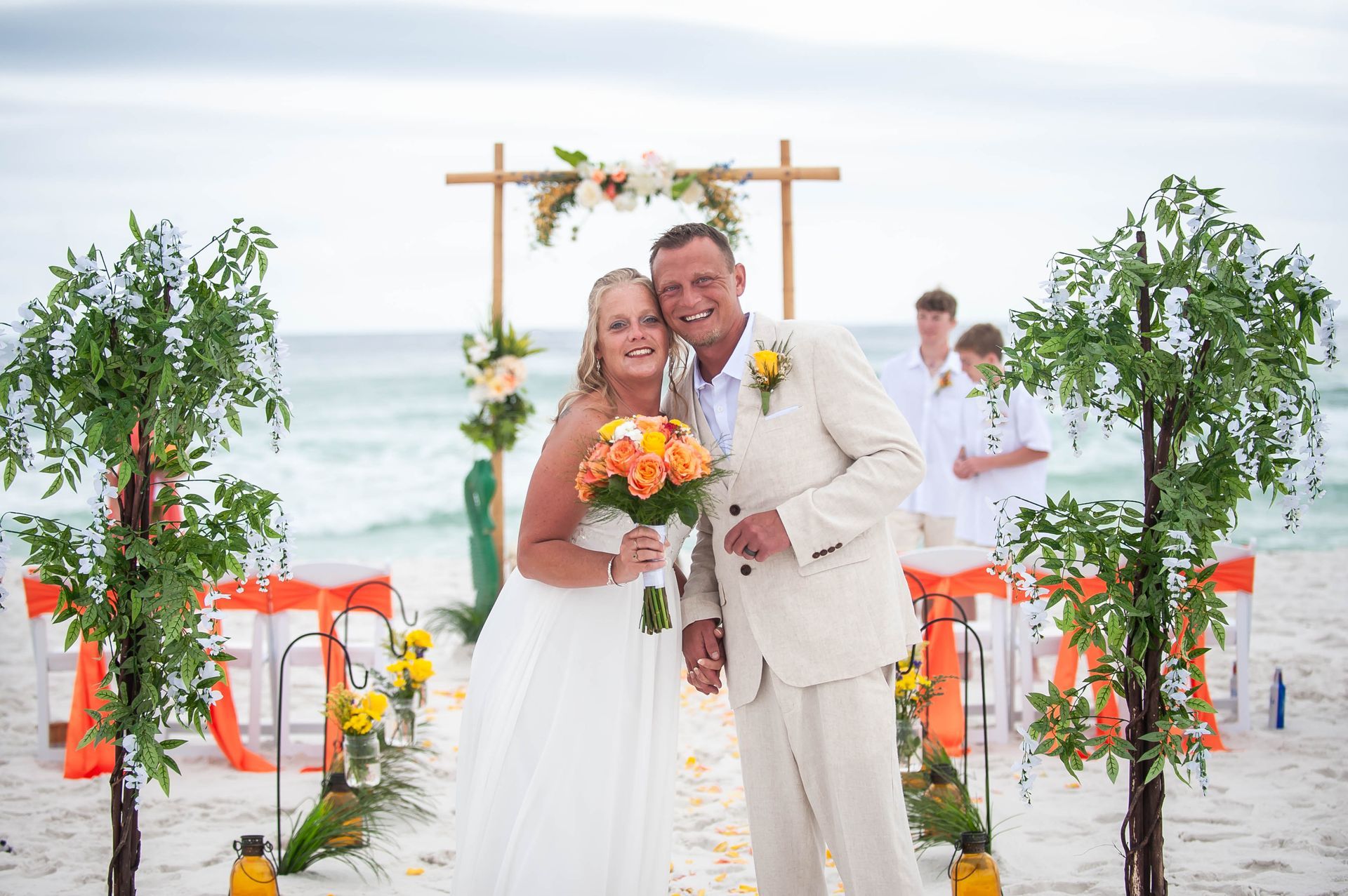 bride and groom smiling in aisle after beach wedding ceremony