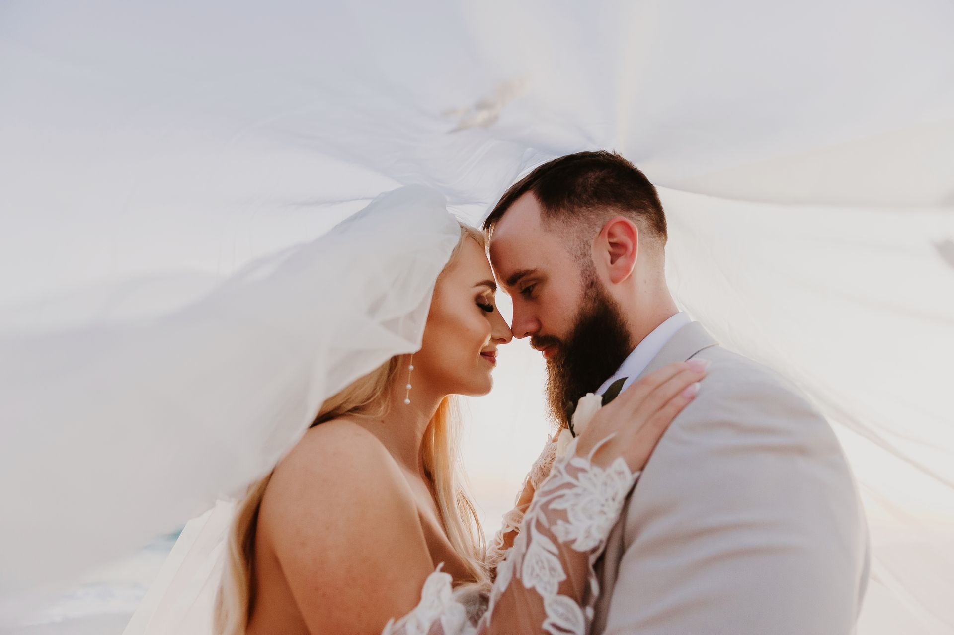 bride and groom embracing while covered by her veil