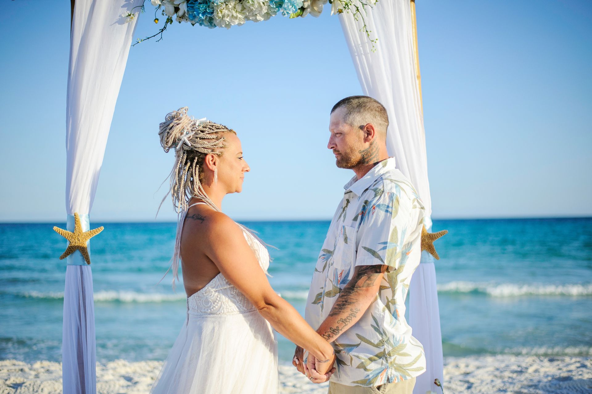 bride and groom holding hands during beach wedding