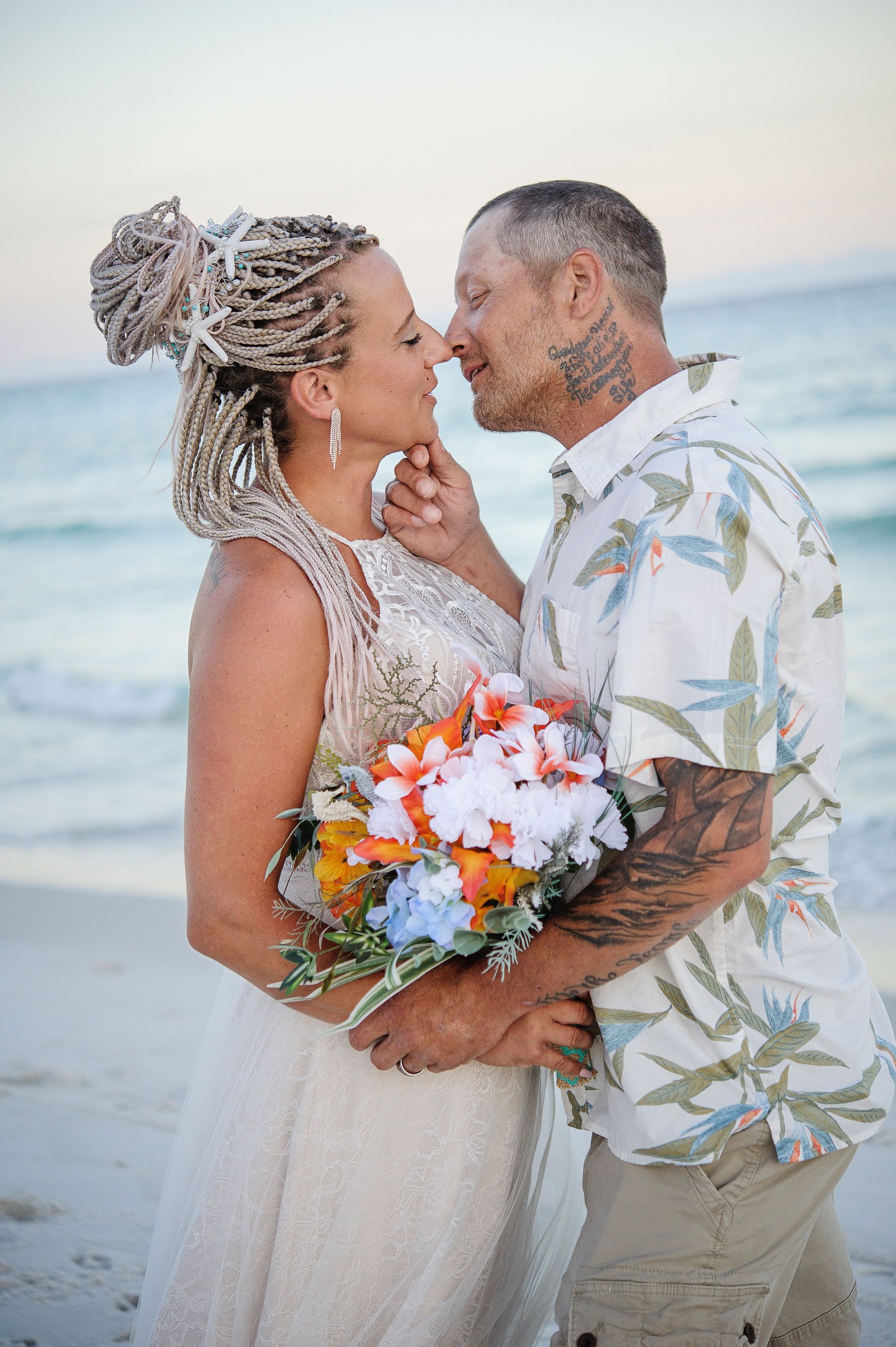 bride and groom kissing during beach wedding