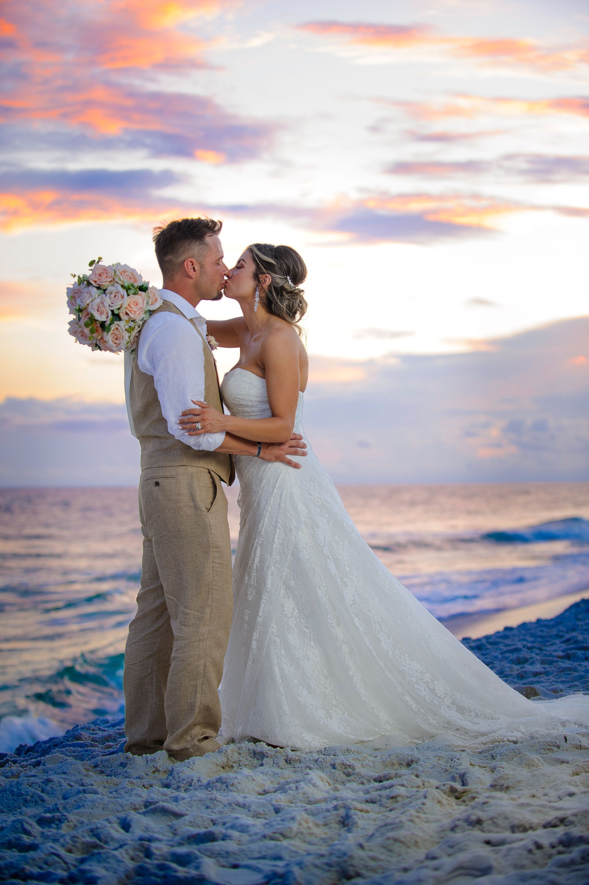 bride and groom kissing during beach wedding