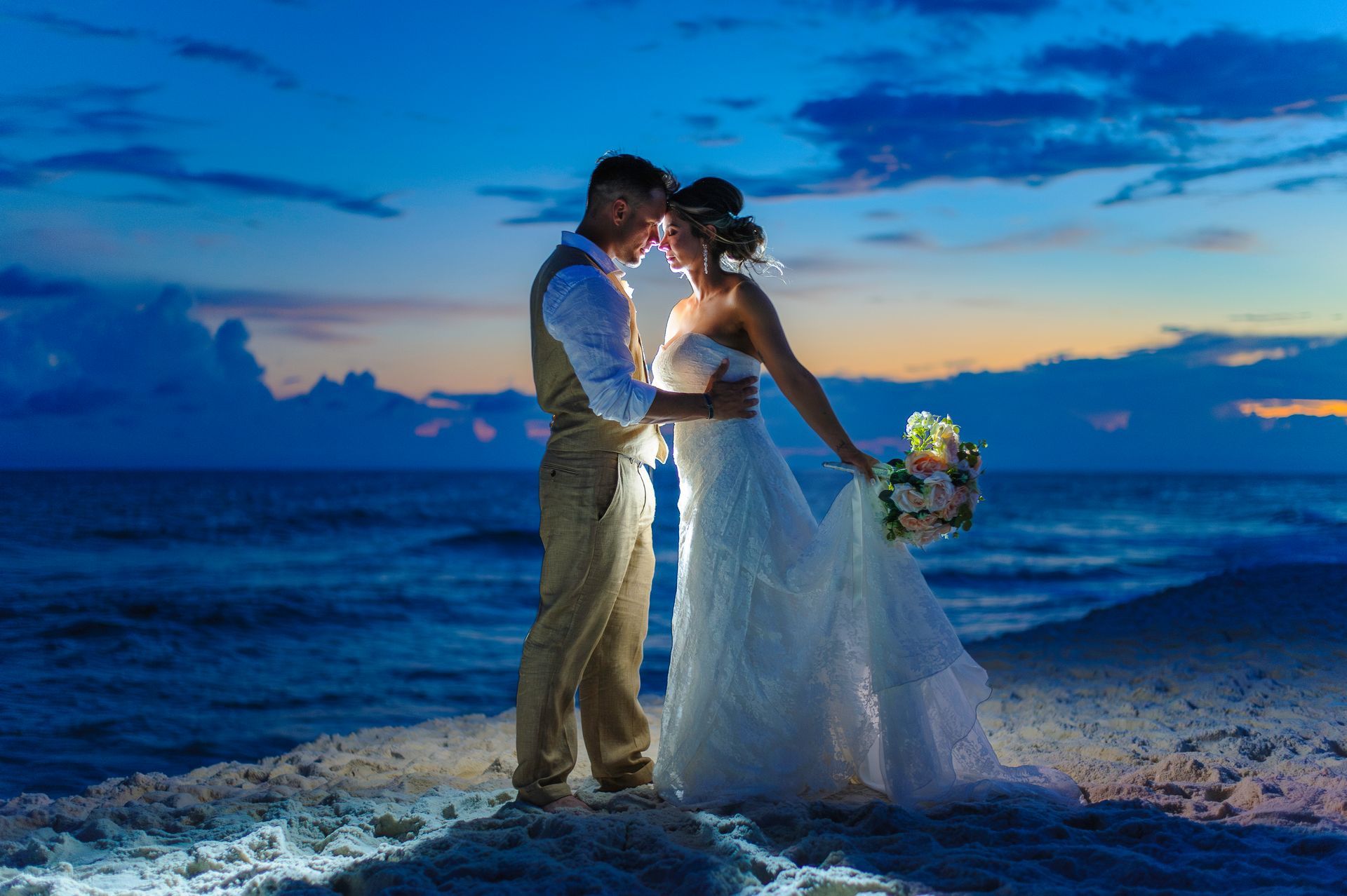 bride and groom embracing on beach