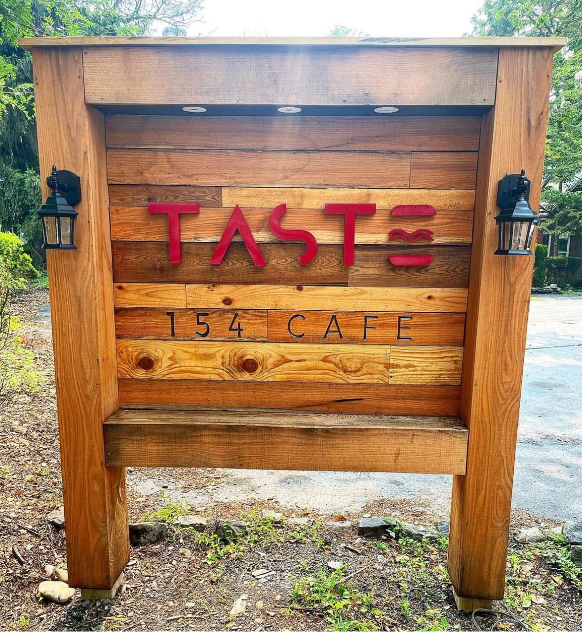 A large wooden sign that says taste on it