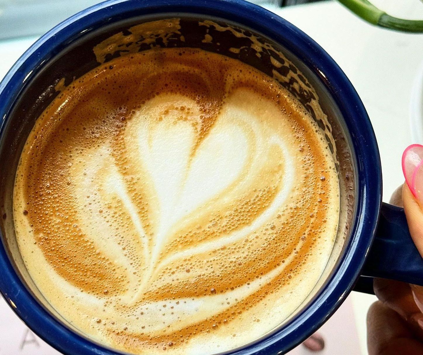 A cup of coffee with a heart shaped latte art
