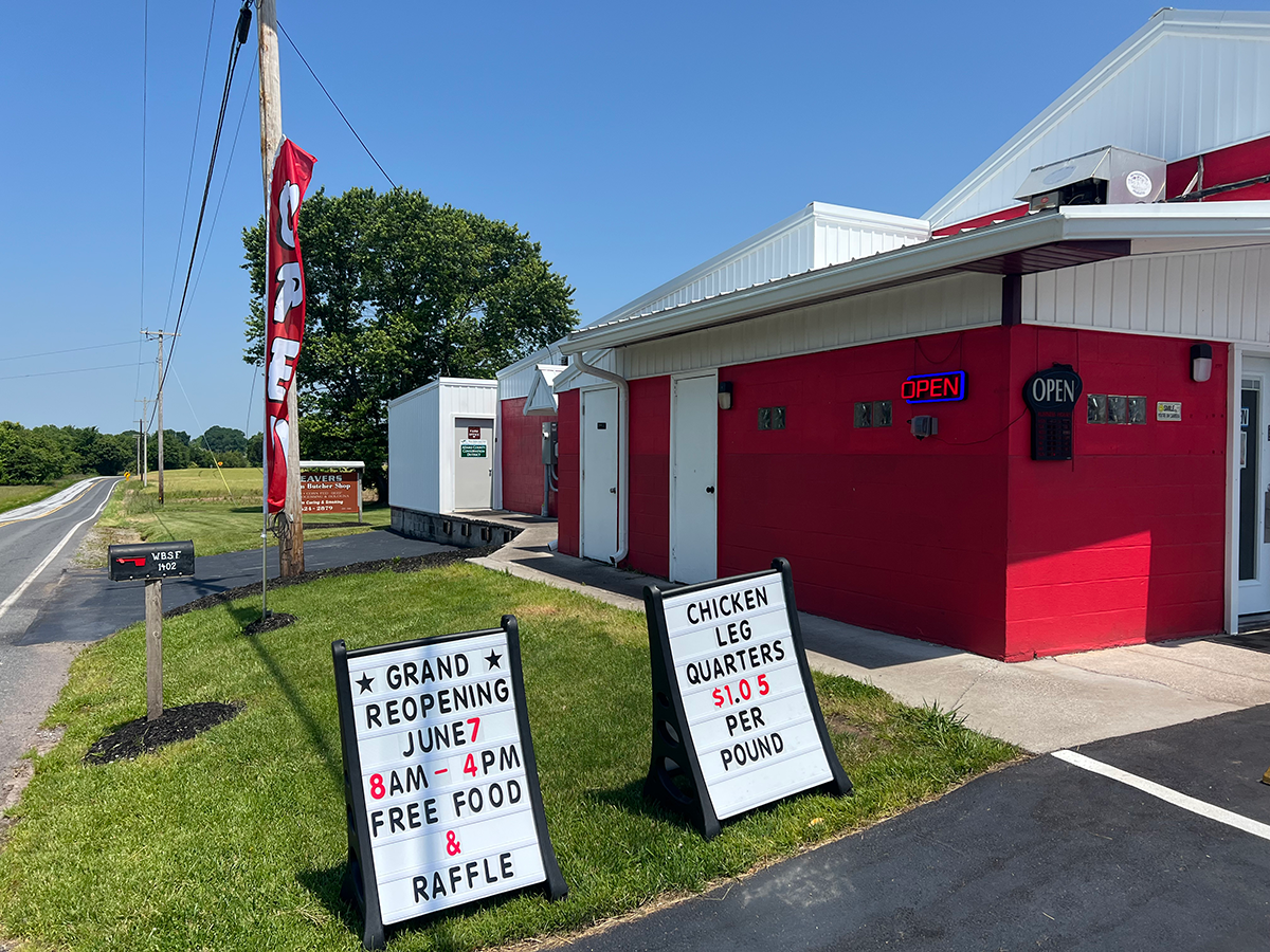 A red and white building with two signs in front of it.