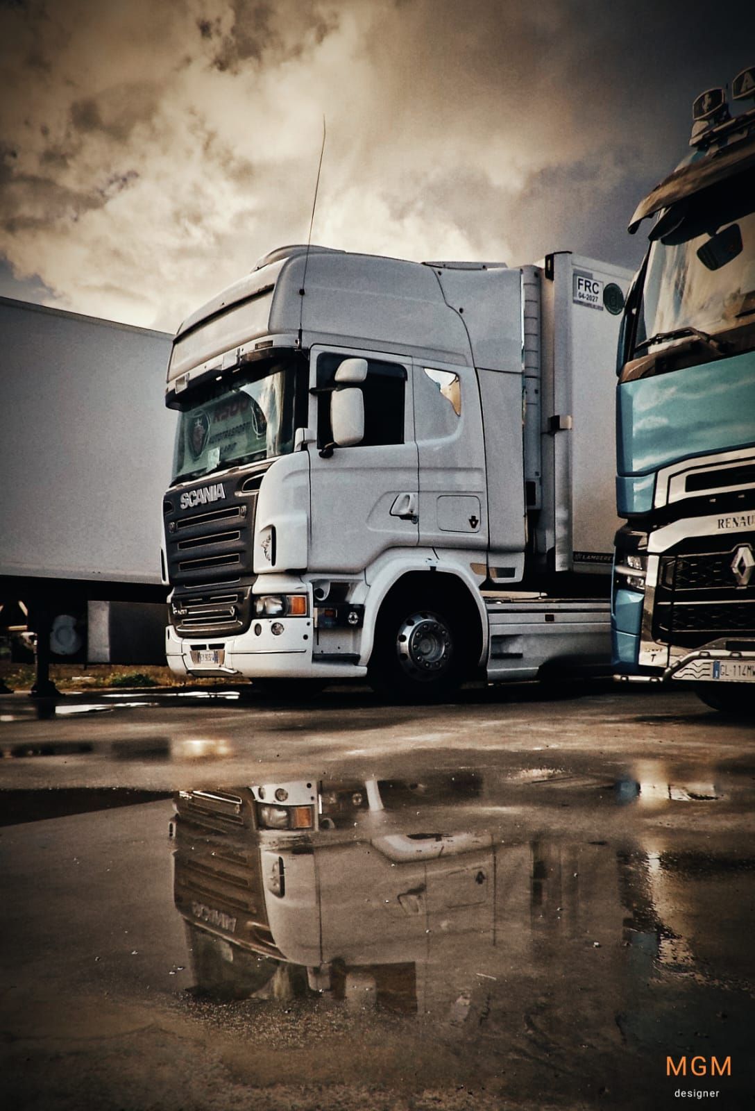 Due camion sono parcheggiati uno accanto all'altro su una strada bagnata.