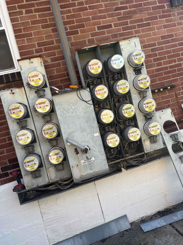 Electrical meters mounted on a brick wall, likely for multiple units.