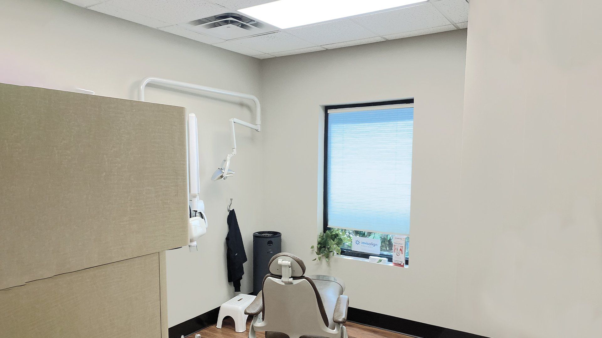 A dental office with a dental chair and a window.