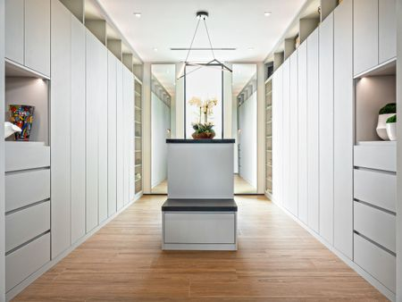 A kitchen with white cabinets and black granite counter tops.