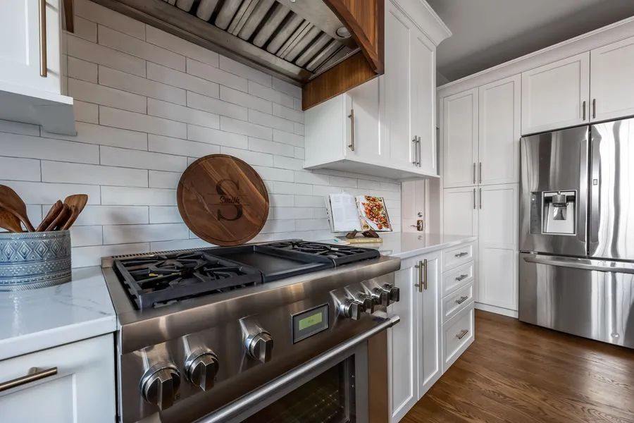 A kitchen with stainless steel appliances and white cabinets.