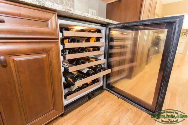 A wine cooler filled with bottles of wine in a kitchen.