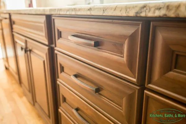 A kitchen with wooden cabinets and a granite counter top.