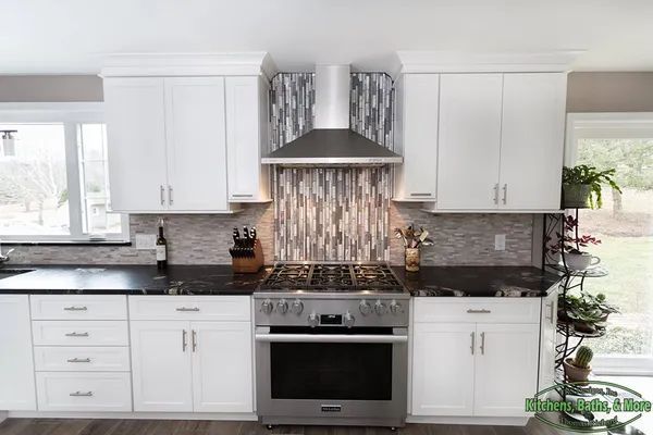A kitchen with white cabinets and stainless steel appliances.