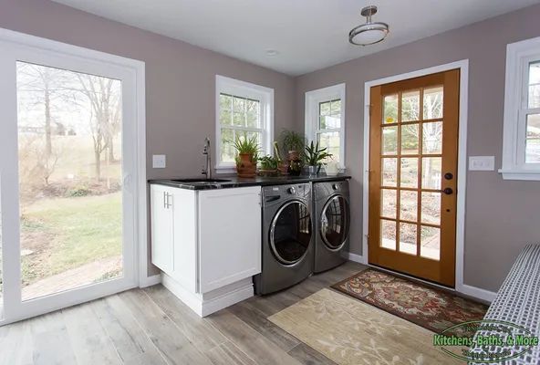 A laundry room with a washer and dryer and a sink.