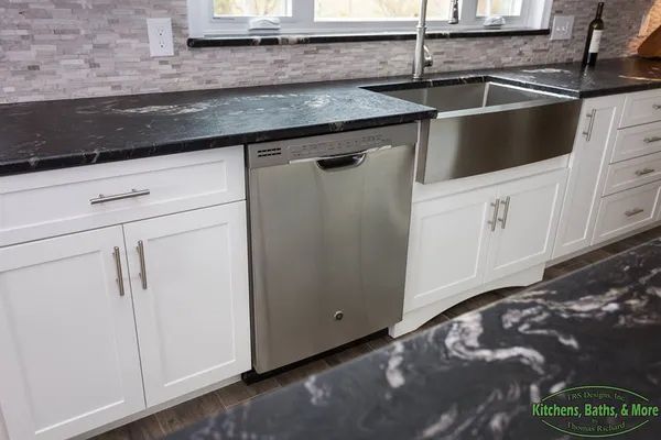 A kitchen with white cabinets and a stainless steel dishwasher.