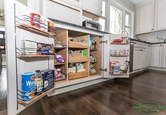 A kitchen with a pantry filled with food and a microwave.