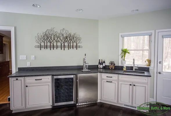 A kitchen with white cabinets, stainless steel appliances, a sink and a refrigerator.