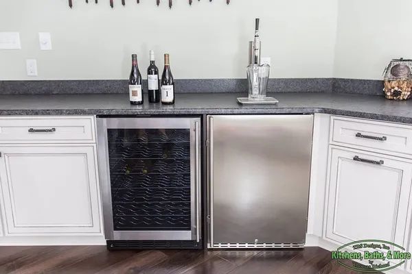 A kitchen with a stainless steel refrigerator and a wine cooler.