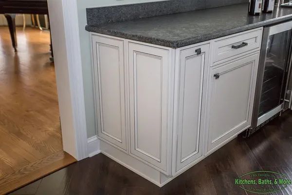 A kitchen with white cabinets and granite counter tops.