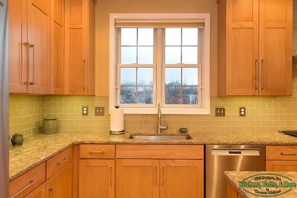 A kitchen with wooden cabinets and stainless steel appliances