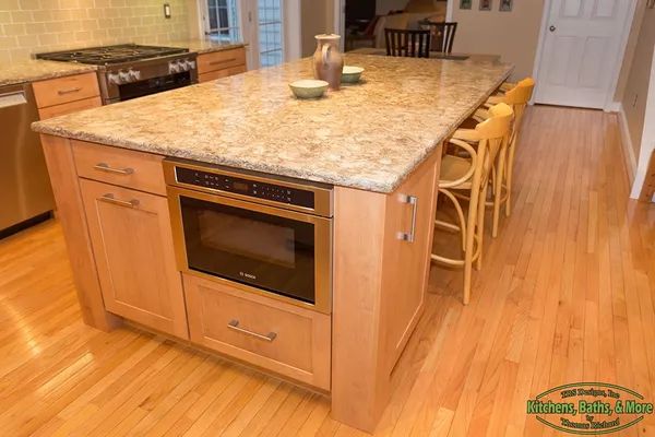 A kitchen with a large island and a microwave oven